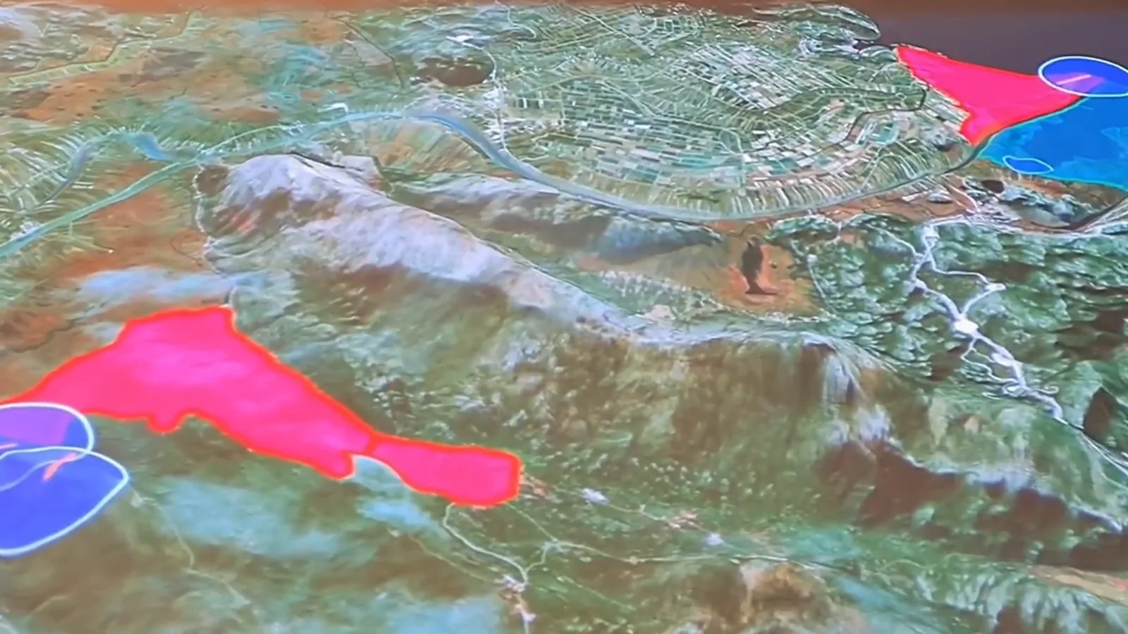 Close-up of the projection on the relief: areas filled in pink and blue across the valley, with circular habitat markers at their edges.